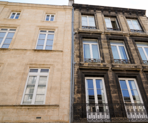 Side-by-side photo of a cleaned building and a dirty building leading to the stone and concrete restoration cleaning products page